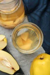 Photo of Delicious quince drink and fresh fruits on grey table, flat lay
