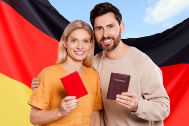 Immigration. Happy couple with passports and national flag of Italy against blue sky