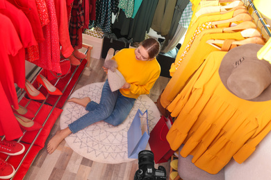 Fashion blogger recording new video in dressing room, above view