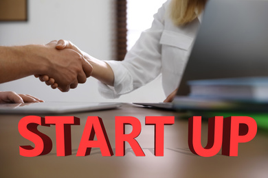Business partners shaking hands at table, closeup. Startup idea