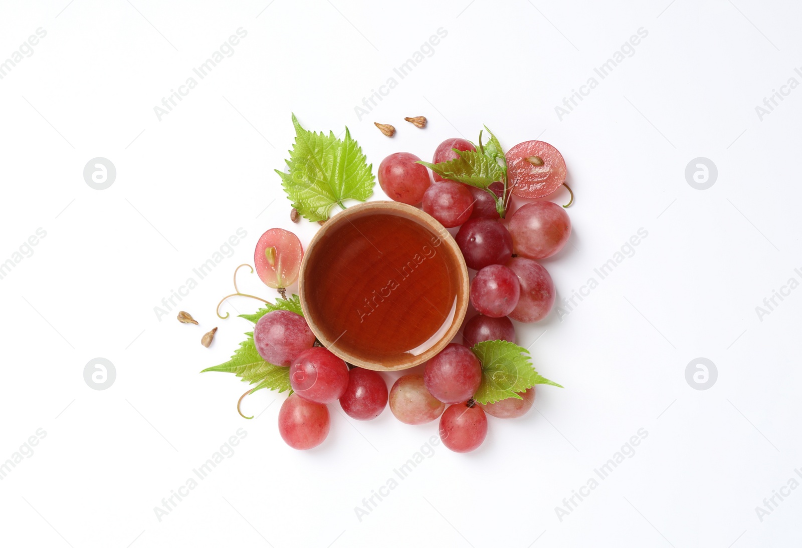 Photo of Composition with wooden bowl of natural grape seed oil on white background, top view. Organic cosmetic