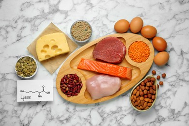 Photo of Different fresh products and paper with Lysine chemical formula on white marble table, flat lay. Sources of essential amino acids