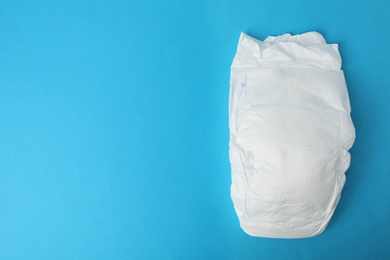 Photo of Baby diaper on blue background, top view. Space for text