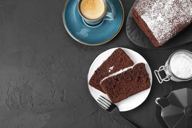 Tasty chocolate sponge cake with powdered sugar and coffee on black textured table, flat lay. Space for text