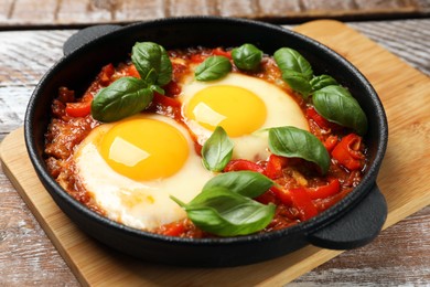 Photo of Delicious Shakshuka on wooden table, closeup view