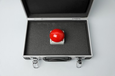 Photo of Red button of nuclear weapon in suitcase on white background, above view. War concept