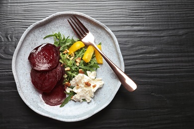 Plate with delicious beet salad on wooden background, top view