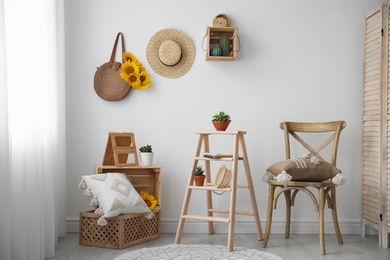 Photo of Bag with bouquet of beautiful sunflowers in stylish room interior