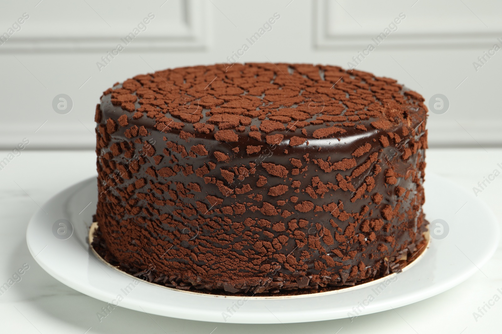 Photo of Delicious chocolate truffle cake on white marble table