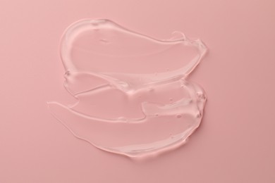 Sample of clear cosmetic gel on pink background, top view