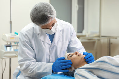 Photo of Doctor preparing female patient for cosmetic surgery in clinic