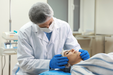 Doctor preparing female patient for cosmetic surgery in clinic