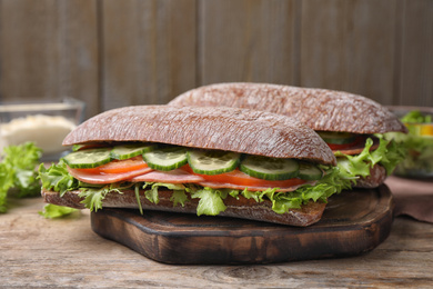 Photo of Tasty sandwiches with ham on wooden table