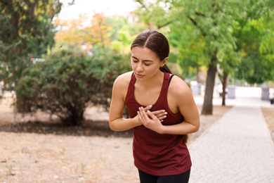 Young woman having heart attack while running in park