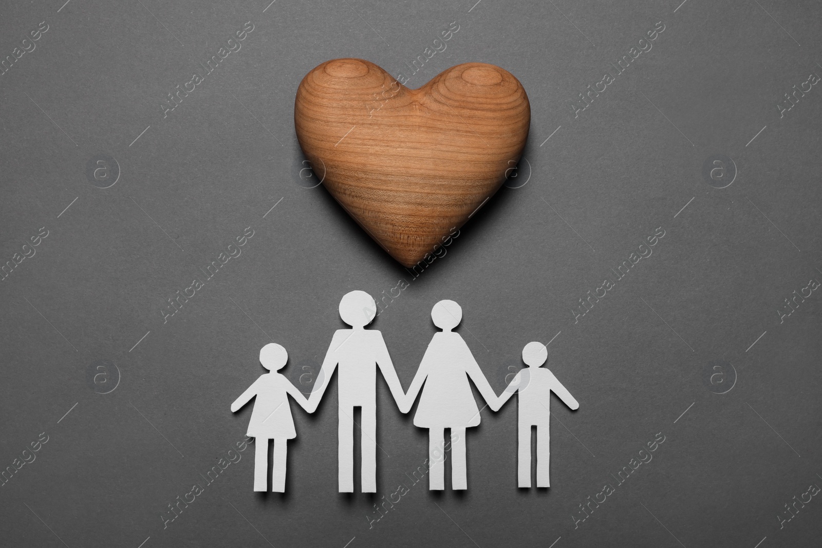 Photo of Paper family figures and wooden heart on grey background, flat lay. Insurance concept
