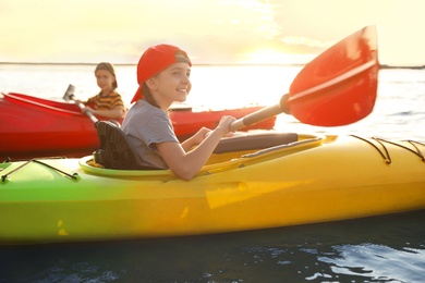 Little children kayaking on river. Summer camp activity