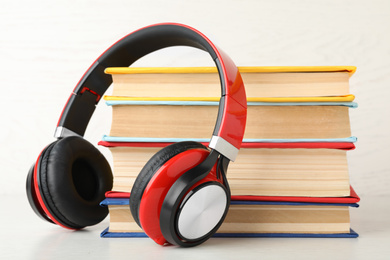 Photo of Books and modern headphones on white table