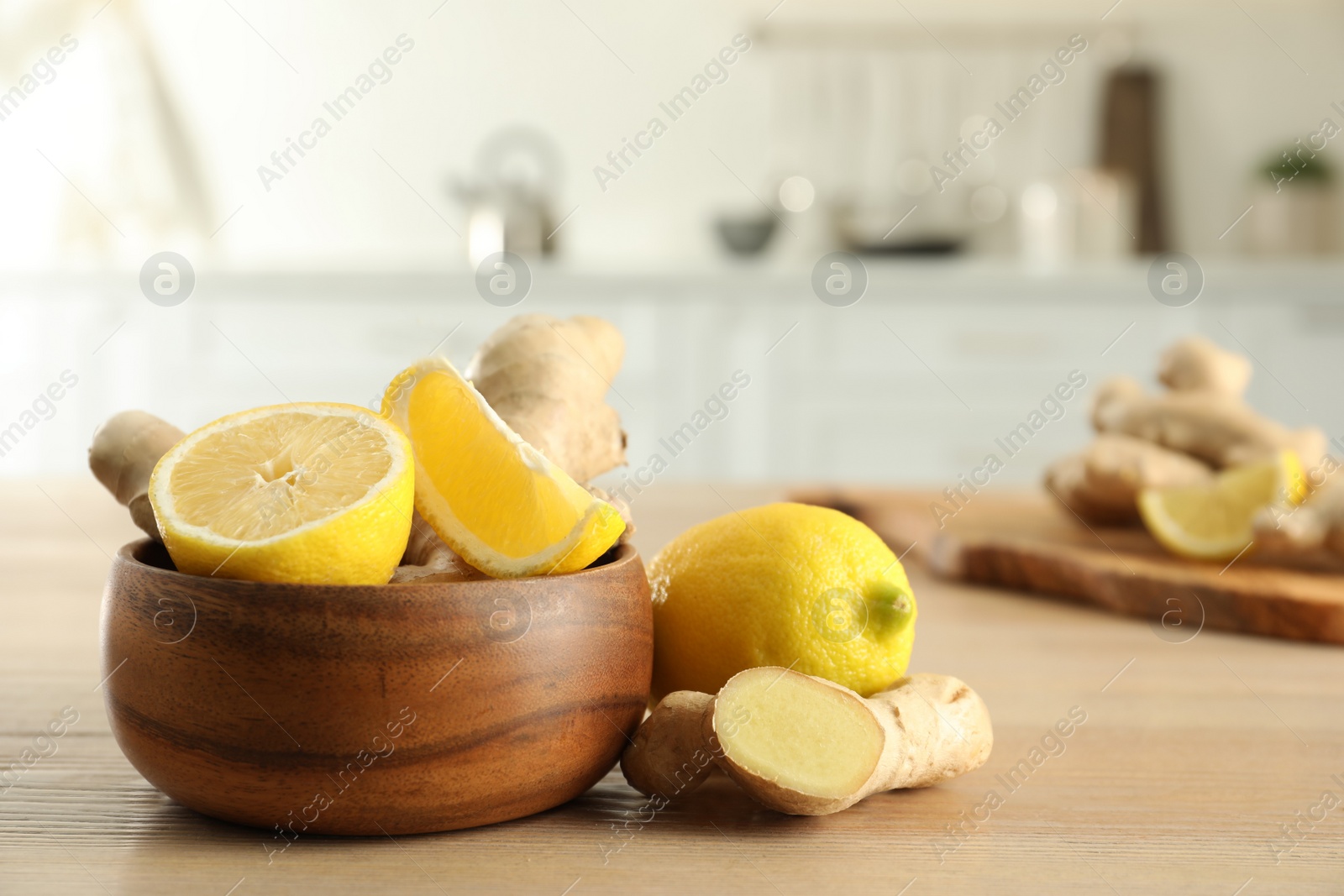 Photo of Fresh lemons and ginger on wooden table indoors