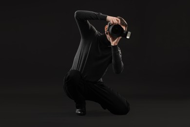 Photo of Professional photographer taking picture on black background
