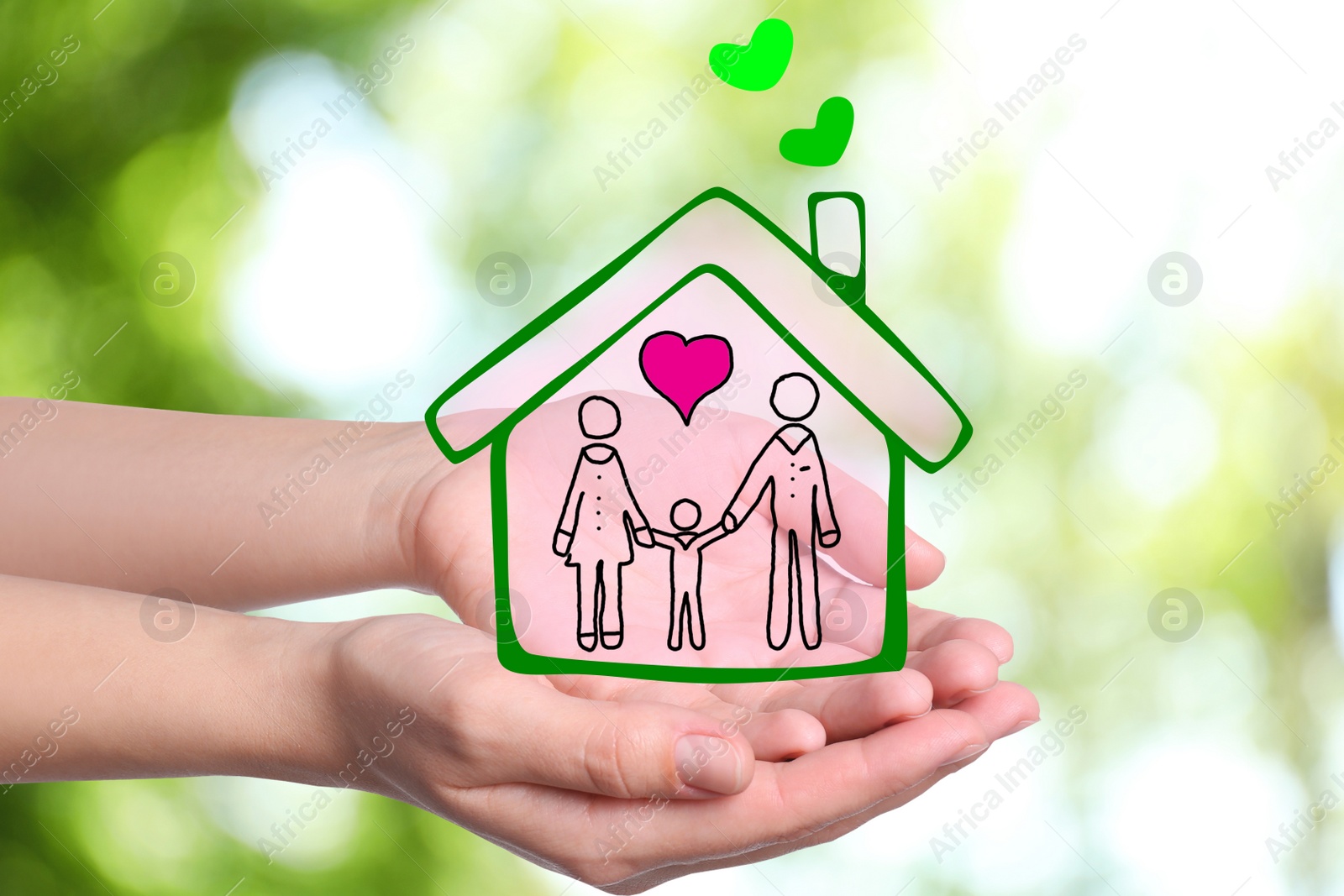 Image of Woman demonstrating illustration of house with family on blurred green background, closeupv