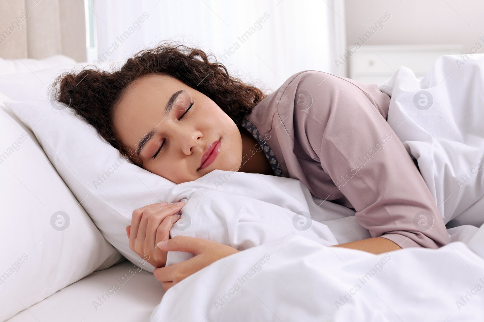 Photo of Beautiful African American woman sleeping in bed at home