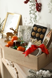Photo of Crate with gift set and Christmas decor on mantelpiece