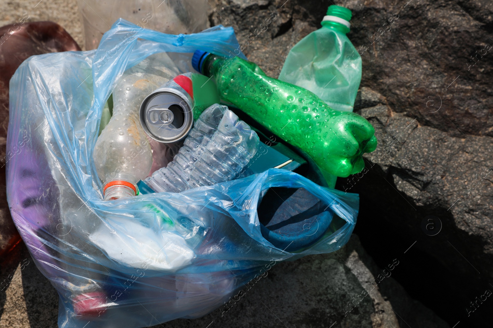 Photo of Garbage on stones outdoors, top view. Environmental Pollution concept