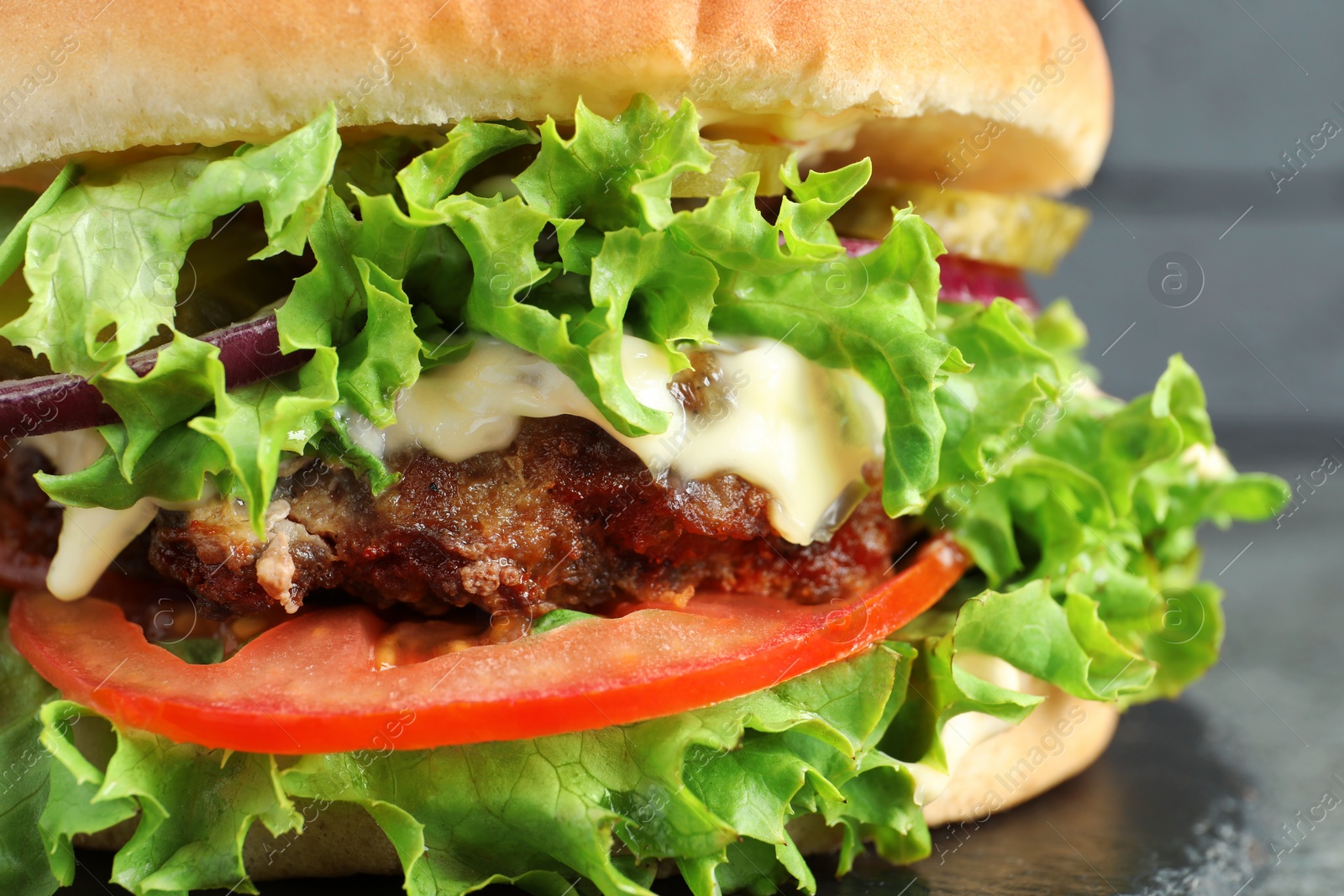 Photo of Delicious burger with beef patty and lettuce on table, closeup