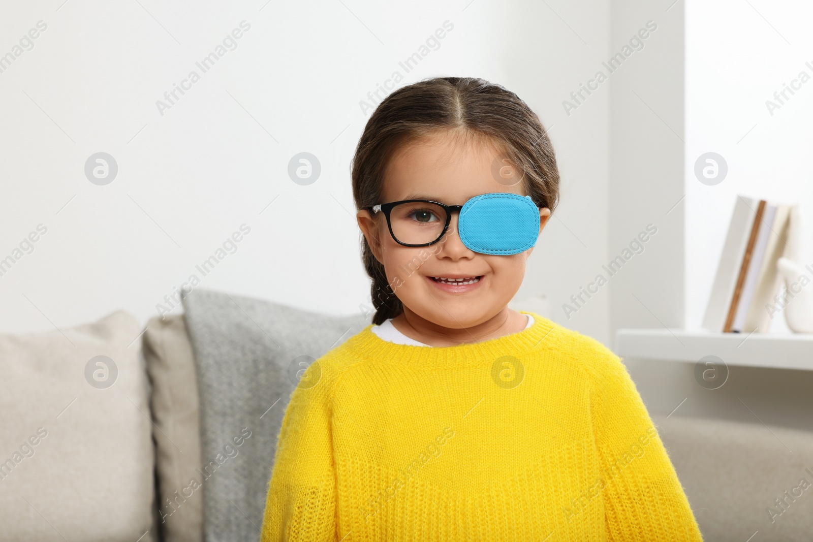 Photo of Happy girl with nozzle on glasses for treatment of strabismus in room