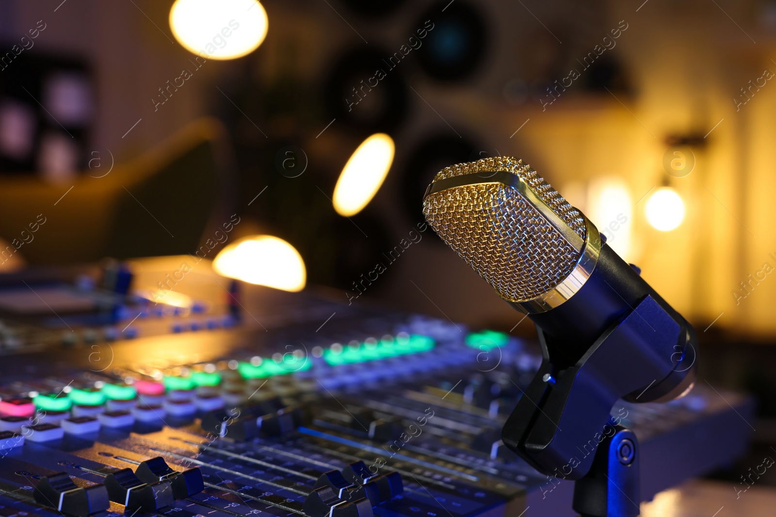 Photo of Microphone near professional mixing console in radio studio, closeup. Space for text