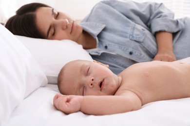 Photo of Mother with her cute baby sleeping in bed