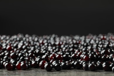 Many elderberries (Sambucus) on grey table, closeup. Space for text