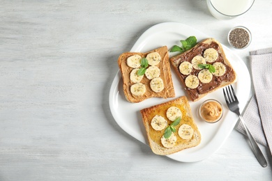 Photo of Tasty toasts with banana, mint and chia seeds served on table, top view. Space for text