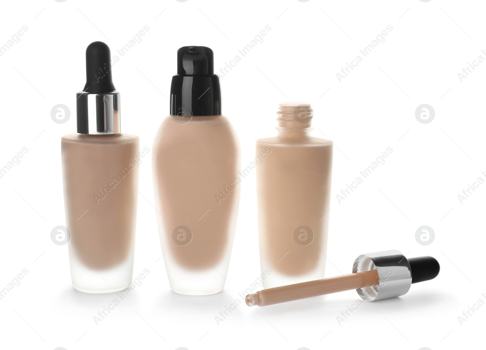 Photo of Bottles of different skin foundations on white background