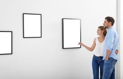 Photo of Couple viewing exposition in modern art gallery