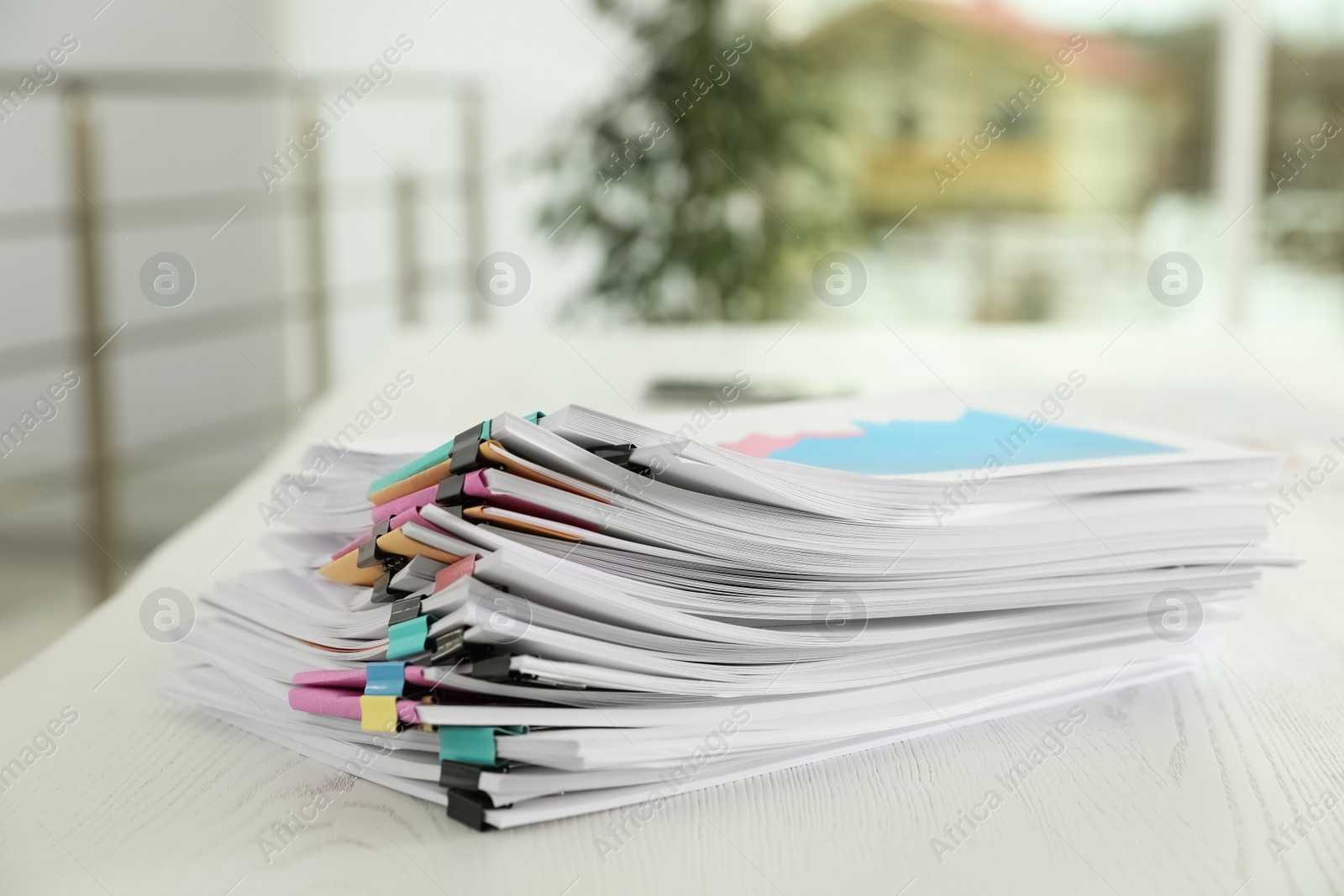 Photo of Stack of documents with paper clips on office table. Space for text