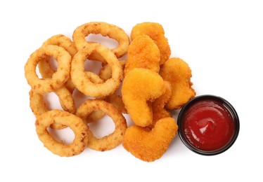 Photo of Tasty fried onion rings, chicken nuggets and ketchup on white background, top view
