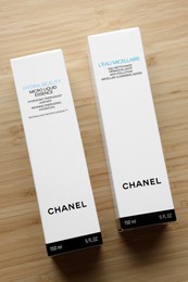 Photo of NETHERLANDS, LEIDEN - JULY 12, 2022: Chanel micellar water and micro liquid essence on wooden table, top view