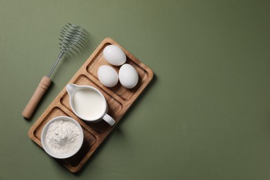Photo of Metal whisk and dough ingredients on khaki background, flat lay. Space for text