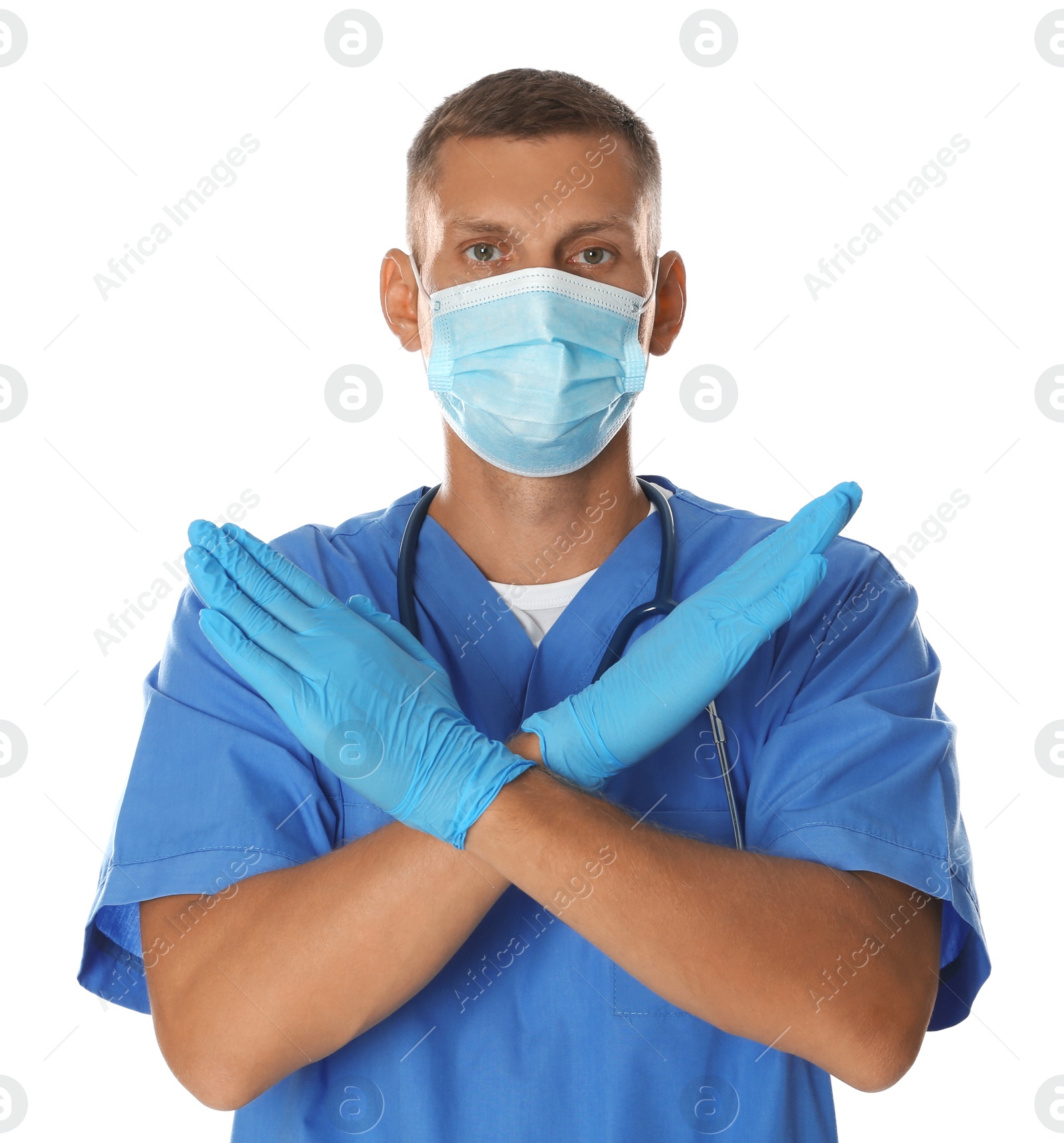 Photo of Doctor in protective mask showing stop gesture on white background. Prevent spreading of coronavirus