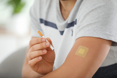 Photo of Man with nicotine patch and cigarette, closeup