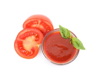 Photo of Bowl of tasty sauce and cut tomato isolated on white, top view