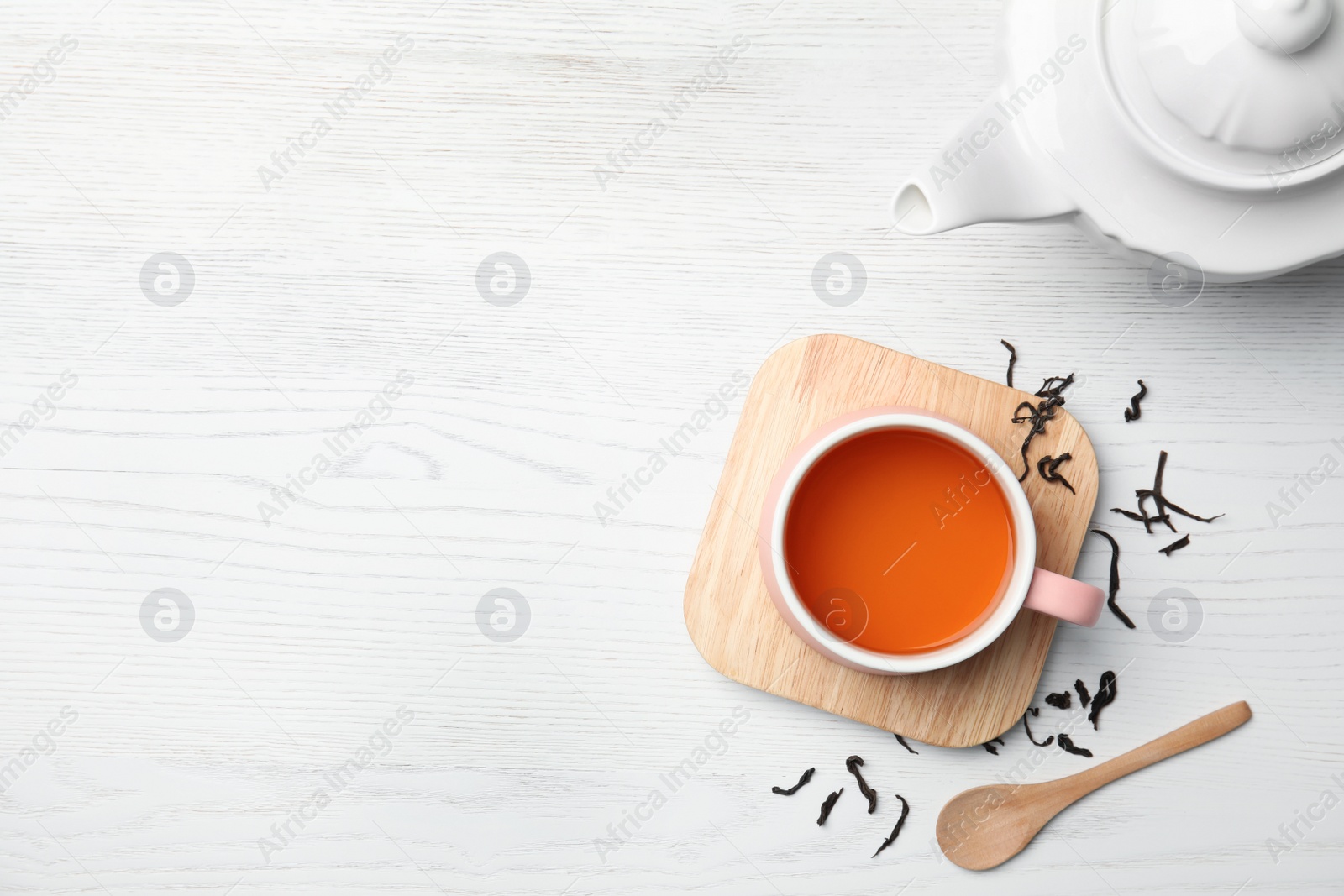 Photo of Cup of black tea on wooden table, top view