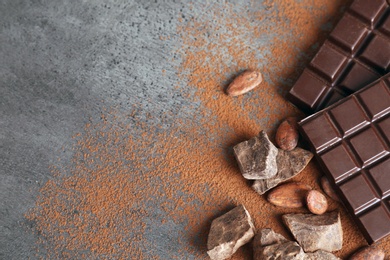 Flat lay composition with cocoa powder and chocolate on grey background