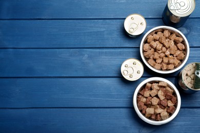 Photo of Wet pet food on blue wooden table, flat lay. Space for text