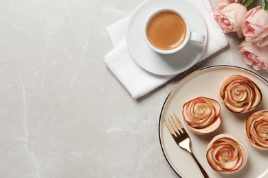 Freshly baked apple roses served on light table, flat lay. Space for text