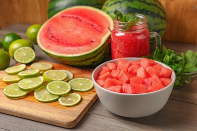 Tasty watermelon drink with lime and fresh ingredients on wooden table