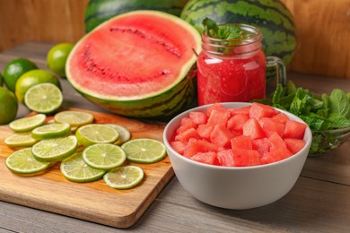 Photo of Tasty watermelon drink with lime and fresh ingredients on wooden table