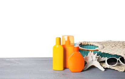 Photo of Sun protection products and beach accessories on grey wooden table against white background. Space for text