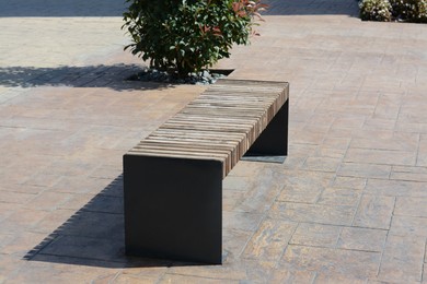 Photo of Wooden bench on city street, space for text